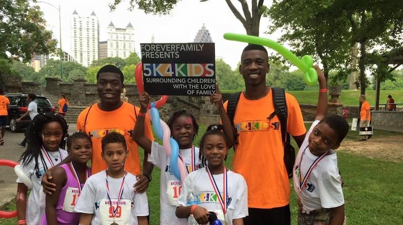 Georgia Tech track teammates Preston Smith, left, and Andréas Ward, right, shown here after a 5K race with the children they coached through Foreverfamily.