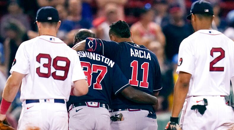 Atlanta Braves' Orlando Arcia (11) is helped from the field by third base coach Ron Washington (37), after an apparent injury, following an RBI single by Arcia, which broke a 6-6 tie, during the tenth inning of a baseball game against the Boston Red Sox, Tuesday, Aug. 9, 2022, in Boston. (AP Photo/Charles Krupa)