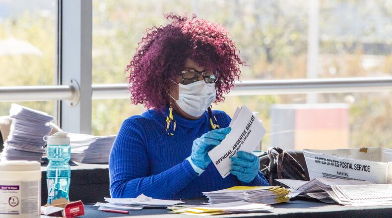 On the suite level at State Farm Arena, Fulton County election officials work to count absentee ballots on Monday, November 2, 2020. The process includes machines that cut open the envelopes, people who sort the paperwork, scanning stations where the data is collected and boxing of the recorded ballots for transport to English Avenue where Fulton County's official count is assessed. The physical ballots and the date will be transported on Tuesday after all absentee ballots are counted. (Jenni Girtman for The Atlanta Journal-Constitution)