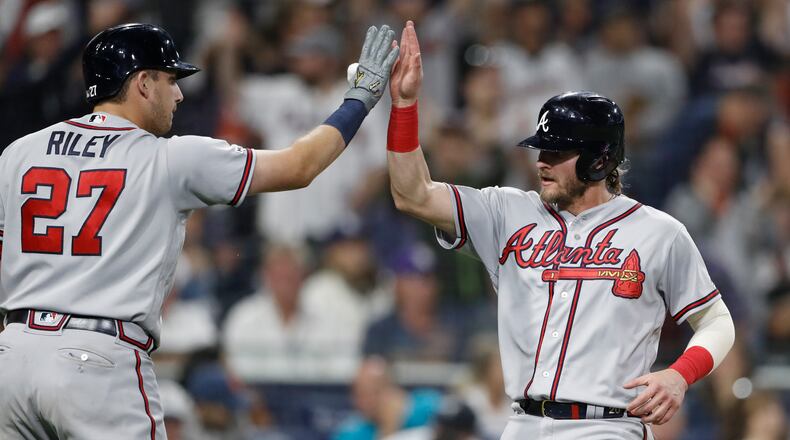 Atlanta Braves' Josh Donaldson, right, is greeted by Austin Riley (27) after scoring on a single by Ozzie Albies during the 10th inning of a baseball game against the San Diego Padres, Saturday, July 13, 2019, in San Diego. (AP Photo/Gregory Bull)