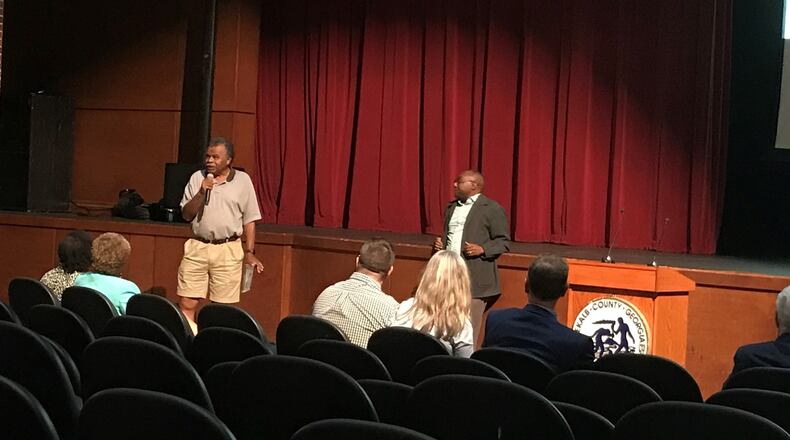 DeKalb County Commissioner Larry Johnson (right) listens as Gresham Park resident Harold Folds voices opposition to a proposal from Blackhall Studios to take control of a portion of Intrenchment Creek Park in South DeKalb. In return, the county would gain ownership of three nearby parcels of land. Folds spoke during public comment at a community meeting about the land swap proposal on Monday, May 20, 2019, at McNair High School. TIA MITCHELL/TIA.MITCHELL@AJC.COM