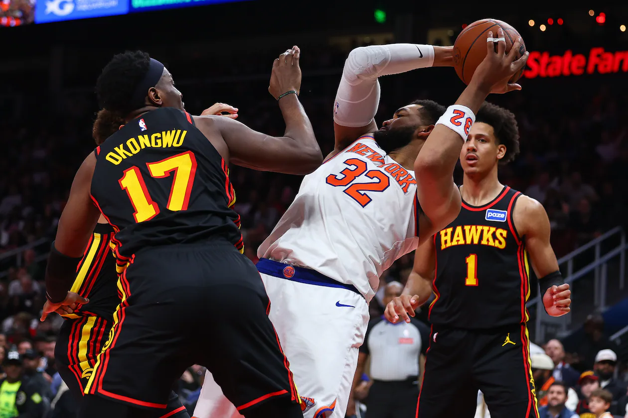 New York Knicks center Karl-Anthony Towns (32) rebounds against Atlanta Hawks forwards Onyeka Okongwu (17) and Jalen Johnson (1) during the second half of an NBA basketball game, Monday, April 6, 2026, in Atlanta. (AP Photo/Colin Hubbard)