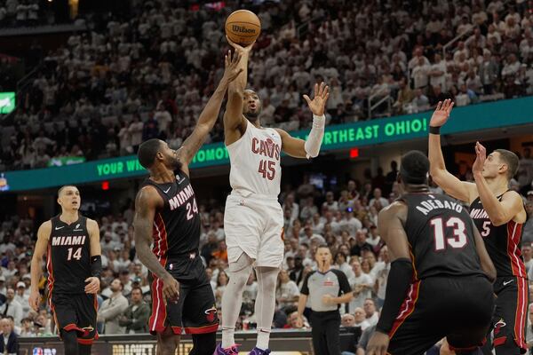 Cleveland Cavaliers guard Donovan Mitchell (45) shoots between Miami Heat's Tyler Herro (14), Haywood Highsmith (24), Bam Adebayo (13) and Nikola Jovic (5) in the second half in Game 2 of an NBA first-round playoff series, Wednesday, April 23, 2025, in Cleveland. (AP Photo/Sue Ogrocki)
