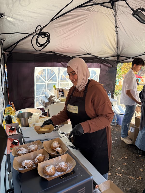 Ekhlass Gzar, whose dream is to open a restaurant, heard about the festival and decided to give it a try. Working with her children, including a medical student and a University of Georgia student, they bought equipment from Goodwill and Amazon and opened "Al Halawani" — hanging a wooden sign the girls carved from an old coffee table. (Ariel Hart/AJC)
