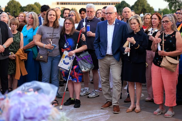 Minnesota Gov. Tim Walz and his wife Gwen Walz attend a candlelight vigil for former House Speaker Melissa Hortman and her husband, Mark, at the State Capitol, Wednesday, June 18, 2025, in St. Paul, Minn. (AP Photo/Nikolas Liepins)