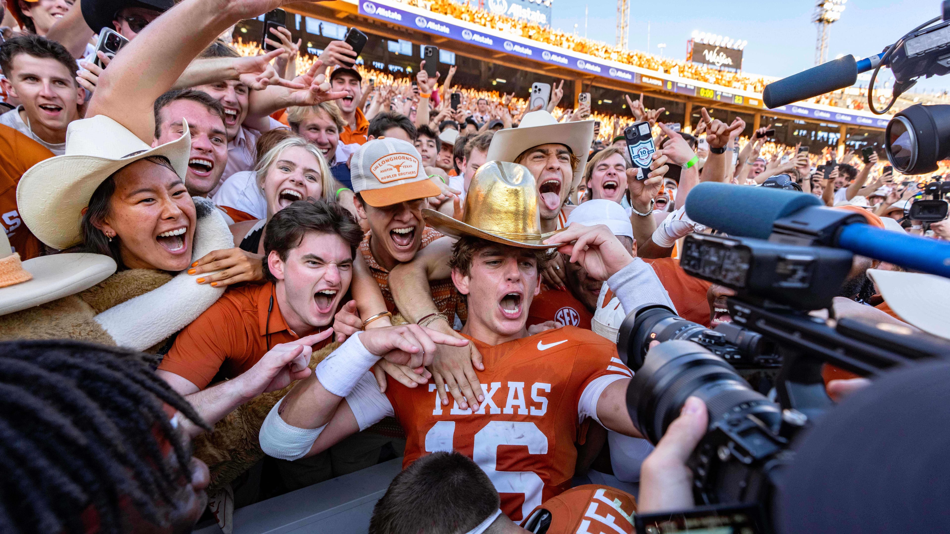 Texas quarterback Arch Manning, center, celebrates with fans after defeating Oklahoma in an NCAA college football game Saturday, Oct. 11, 2025, in Dallas. (AP Photo/Jeffrey McWhorter)