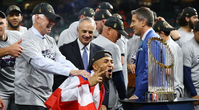 110221 HOUSTON: Braves outfielder Eddie Rosario takes in a closer view of the Commissioner's Trophy while getting a pat on the back from Chairman and CEO Terry McGuirk after beating the Astros in game 6 to win the World Series on Tuesday, Nov. 2, 2021, in Houston.   “Curtis Compton / Curtis.Compton@ajc.com”