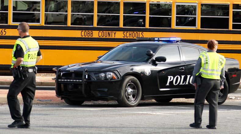 Two McEachern High School students were previously arrested in a shooting in the campus parking lot, police said. A third suspect, who was injured in the shooting, is facing charges.