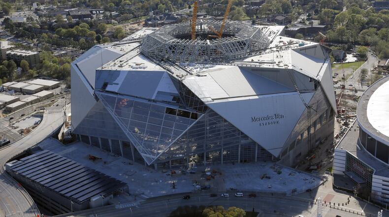 Mercedes-Benz Stadium sits next to the Georgia Dome. Aerial photo was taken last Friday. BOB ANDRES /BANDRES@AJC.COM