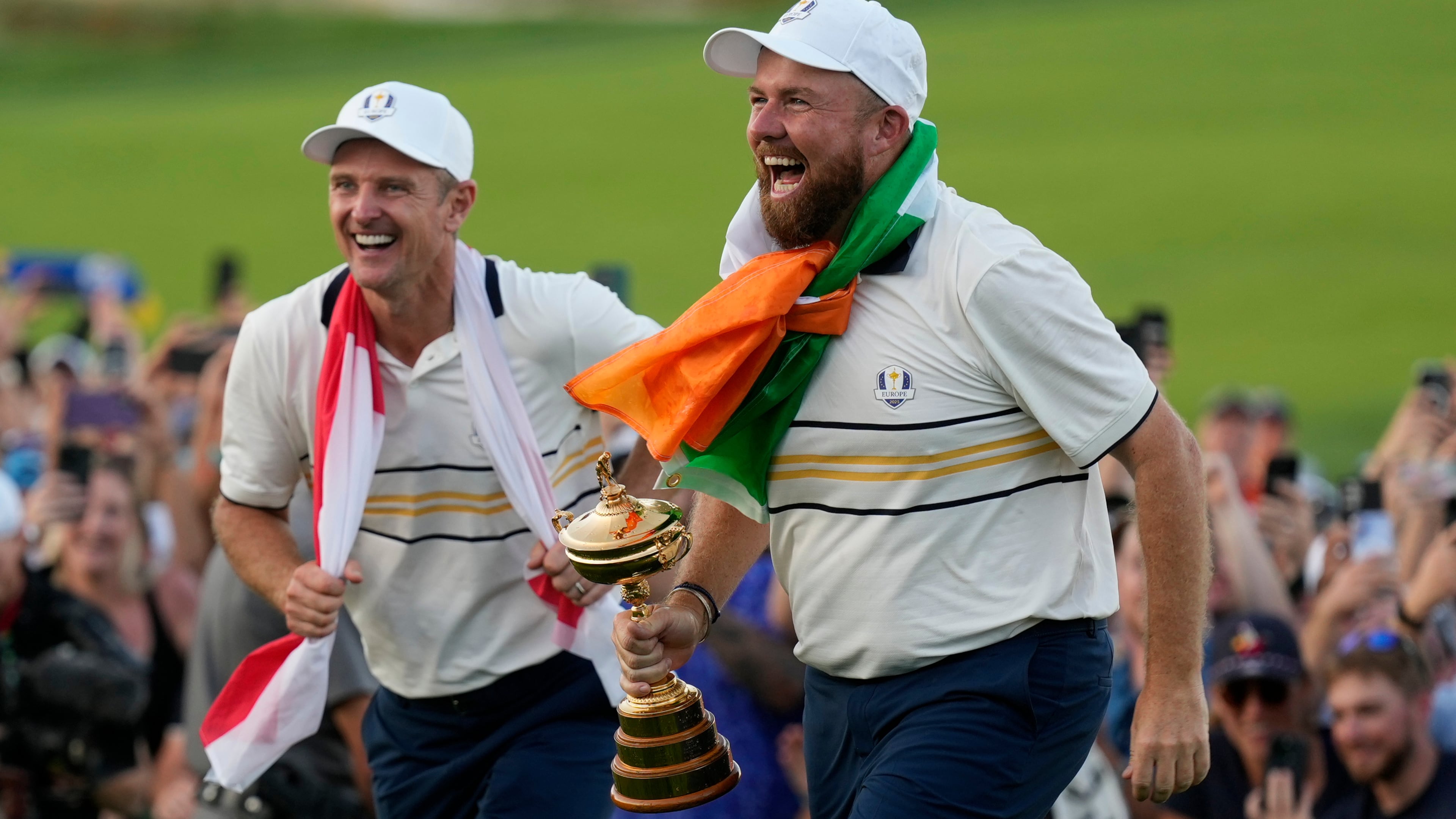 Europe's Shane Lowry and Justin Rose celebrate with the trophy after winning the Ryder Cup golf tournament against the United States on the Bethpage Black golf course, Sunday, Sept. 28, 2025, in Farmingdale, N.Y. (AP Photo/Robert Bukaty)
