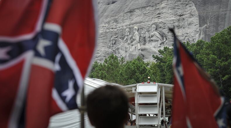 Confederate flag sympathizers march past the carved monument at Stone Mountain Park to protest what they believe is an attack on their Southern heritage. (John Amis/ AJC 2015 file photo)