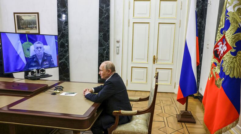 Russian Strategic Missile Forces chief, Col. Gen. Sergei Karakayev, left on the screen, reports to President Vladimir Putin on a successful test launch of the Sarmat intercontinental ballistic missile at the Kremlin in Moscow, Tuesday, May 12, 2026. (Mikhail Metzel/Sputnik, Kremlin Pool Photo via AP)