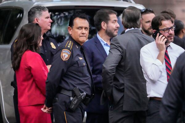Harris County Sheriff Ed Gonzalez stands with local officials as law enforcement officers investigate the scene where a Harris County deputy and a suspect were shot outside the Family Law Center in Houston, Monday, April 21, 2025. (Brett Coomer/Houston Chronicle via AP)
