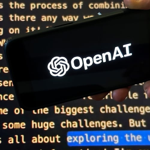FILE - The OpenAI logo appears on a mobile phone in front of a screen showing part of the company website in this photo taken on Nov. 21, 2023 in New York. (AP Photo/Peter Morgan, File)