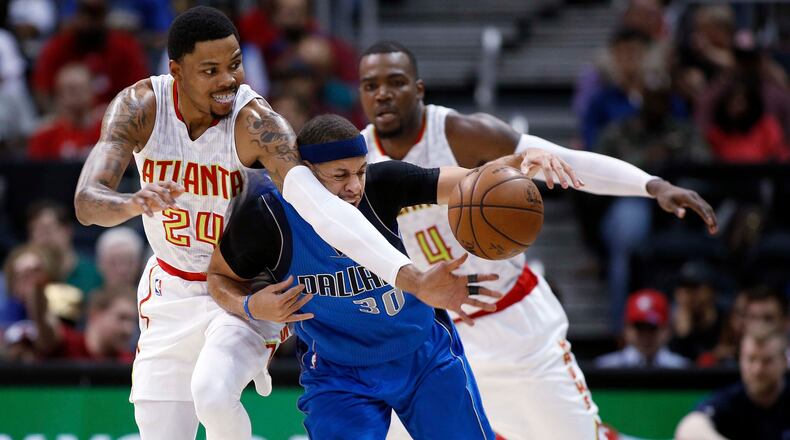 Atlanta Hawks forward Kent Bazemore (24), left, and Atlanta Hawks forward Paul Millsap (4) try to steal the ball from Dallas Mavericks guard Seth Curry (30) during the first half of an NBA basketball game, Wednesday, March 1, 2017, in Atlanta. (AP Photo/AJ Reynolds)