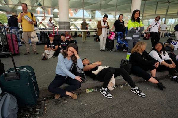 Passengers wait outside Atocha train station during a nationwide power outage in Madrid, Monday, April 28, 2025. (AP Photo/Manu Fernandez)