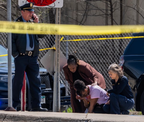 A police officer works on the scene as a bystander is shook up by the homicide in front of 2107 Cedar Ave S in Minneapolis, Minn., on Wednesday, April 30, 2025. (Richard Tsong-Taatarii/Star Tribune via AP)