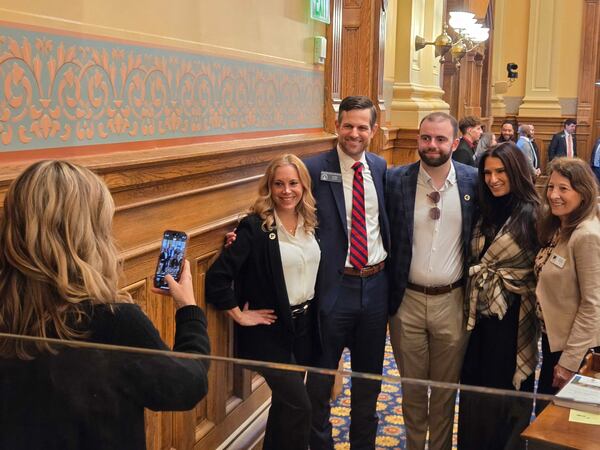 "Love on the Spectrum" star Connor Tomlinson (center) is urging Georgia lawmakers to pass a bill creating an autism specialty license plate and requiring first responders to be trained in autism response. From left: Layla Luna (autism advocate and founder of Just Bee), Sen. Brian Strickland, Connor Tomlinson, Lise Smith (Connor's mother) and Sharon Twaddell (COO of Just Bee). Taking the photo is Strickland's wife Lindsay. (Maya Prabhu/AJC)