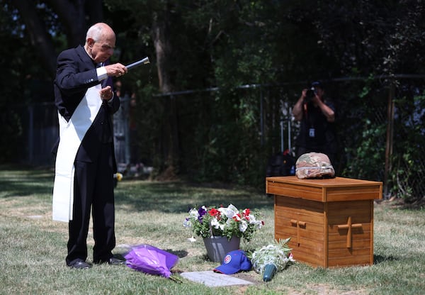 Deacon Glenn Tylutki, of Chicago Catholic Cemeteries, blesses the grave of 75-year-old Pfc. Reba C. Bailey, a former missing person cold case named Seven Doe, during a military funeral Tuesday, July 1, 2025, at Mount Olivet Catholic Cemetery in Chicago. (AP Photo/Talia Sprague)