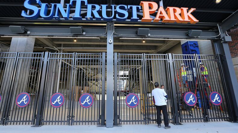 Melvin Jones, Marietta, and his 1-year-old grandson Deandre Jones, take a sneak peak of SunTrust Park, the new home of the Braves, through the third-base gate on Monday, March 20, 2017. (Curtis Compton/ccompton@ajc.com)
