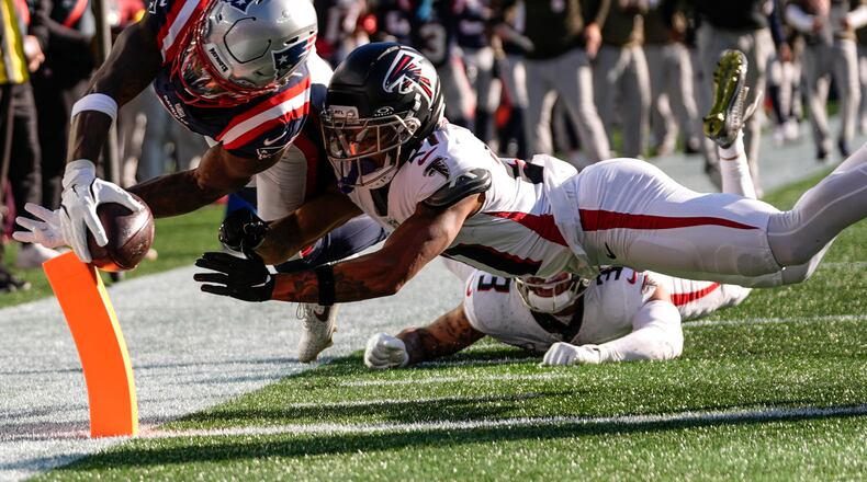 New England Patriots wide receiver Stefon Diggs (8) scores a touchdown against Atlanta Falcons cornerback Mike Hughes (21) during the first half of an NFL football game, Sunday, Nov. 2, 2025, in Foxborough, Mass. (AP Photo/Charles Krupa)