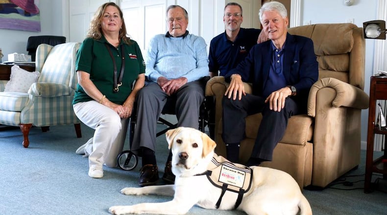 Former President George H.W. Bush, second left, poses for a photo with Sully, a yellow Labrador retriever who'll be his first service dog at his home in Kennebunkport, Maine, Monday, June 25, 2018. The 94-year-old and his new companion got acquainted Monday at the Bush family compound on the coast of Maine. Photographed with Bush are Valerie Cramer, from left, Brad Hubbard, from America's VetDogs, and former President Bill Clinton, visiting Bush. Sully was trained by the nonprofit that provides service dogs. (Evan F. Sisley/Office of George Bush via AP)