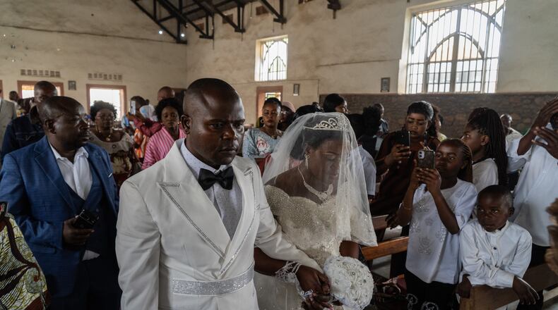 A newly married couple walks down the aisle at their wedding amid an Ebola outbreak in Ituri Province in Bunia, Congo, Saturday, June 6, 2026. (AP Photo/Moses Sawasawa)