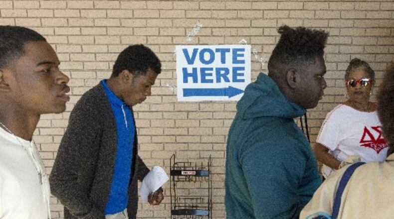 Columbia High School Students head into the polling location in Atlanta, on Monday. The group of Columbia High School seniors will be early voting as a part of their coursework and to build familiarity with the electoral process. (DAVID BARNES / DAVID.BARNES@AJC.COM)