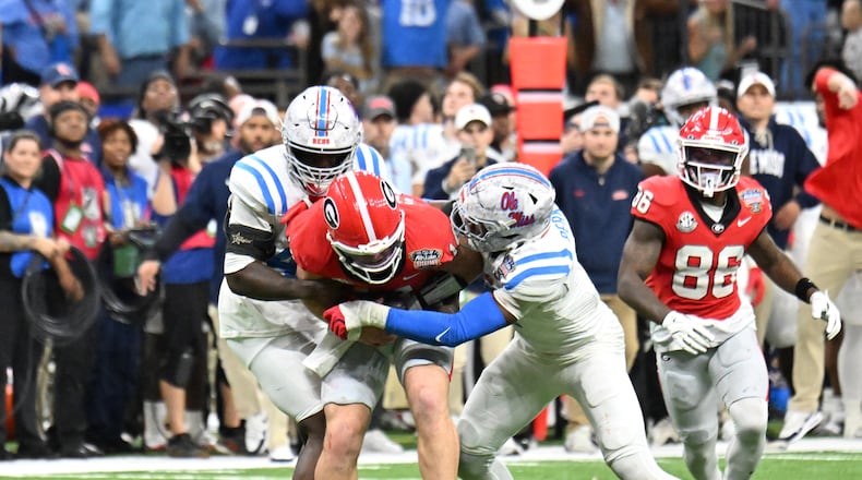 One former NFL scout said of Georgia quarterback Gunner Stockton (center), pictured being tackled against Ole Miss in the Sugar Bowl College Football Playoff game in January: "He’s a talented kid and a great leader, but we have to see if the traits equate to the NFL.” (Hyosub Shin/AJC)