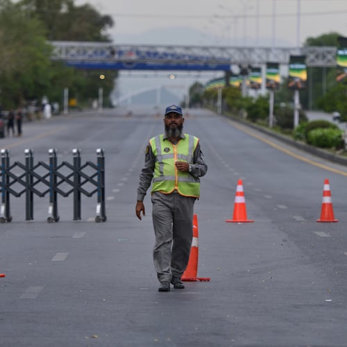 A police officer stands to divert traffic on a road barricaded by authorities due to security arrangements for possible second round of talks between the U.S. and Iran, in Islamabad, Pakistan, Friday, April 24, 2026. (AP Photo/M.A. Sheikh)