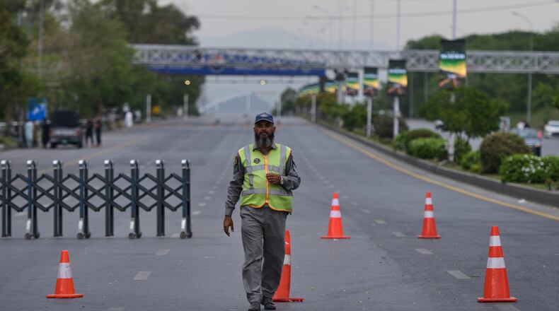 A police officer stands to divert traffic on a road barricaded by authorities due to security arrangements for possible second round of talks between the U.S. and Iran, in Islamabad, Pakistan, Friday, April 24, 2026. (AP Photo/M.A. Sheikh)
