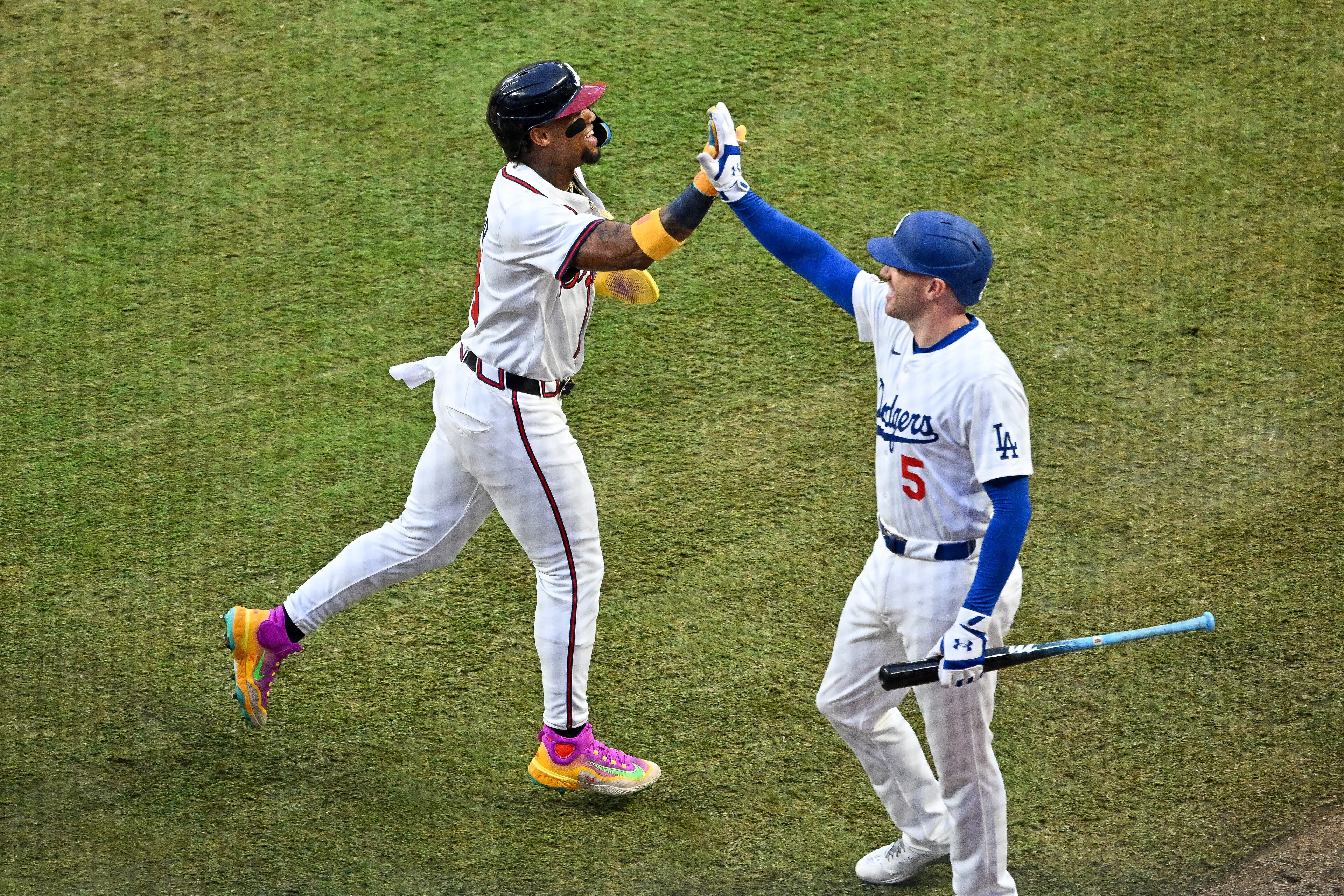 The National League's Ronald Acuña Jr. of the Atlanta Braves celebrates with Freddie Freeman of the Los Angeles Dodgers after scoring a run against the American League during the first inning of the MLB All-Star Game at Truist Park in Atlanta on Tuesday, July 15, 2025. (Hyosub Shin/AJC)