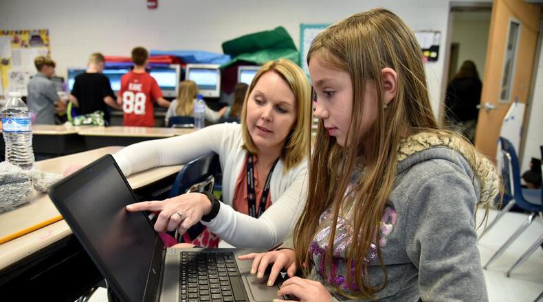 Forsyth County’s Chestatee Elementary School teacher Joy Hall helps fourth-grader Raine Wilson with a writing assignment during class. The Forsyth School Board on Oct. 8 will receive a proposed redistricting map that may affect children at Sawnee, Matt, Kelly Mill, Silver City and Coal Mountain elementary schools. AJC FILE