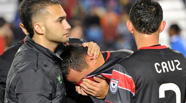 Atlanta Silverbacks midfielder Richard Menjivar (center) is comforted by teammates and staff after they lost to the New York Cosmos during the NASL Soccer Bowl 2013 at Atlanta Silverbacks Park HYOSUB SHIN / HSHIN@AJC.COM