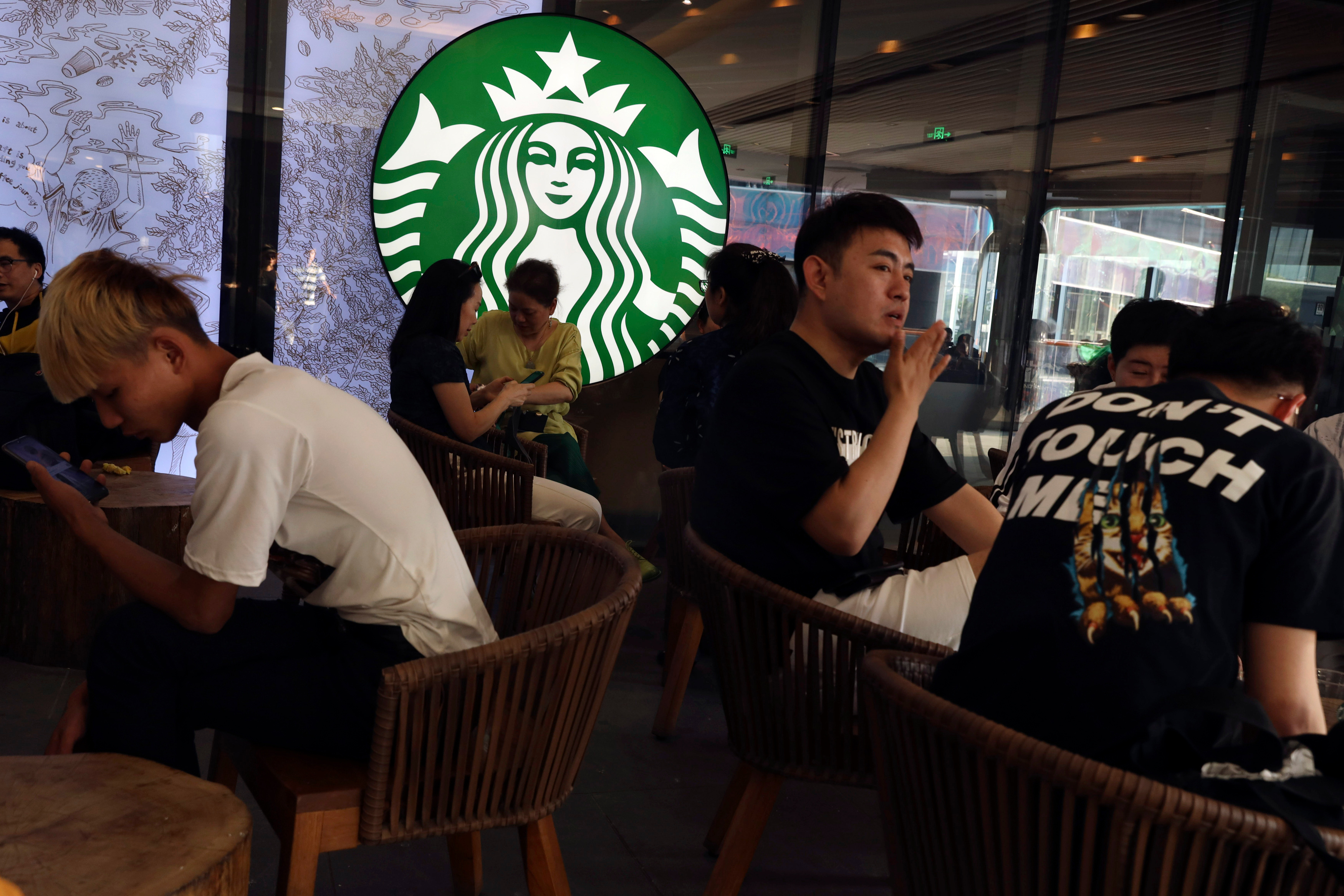 FILE - Chinese customers enjoy their drinks at a store of U.S. coffee giant Starbucks in Beijing on May 10, 2019. (AP Photo/Ng Han Guan, File)