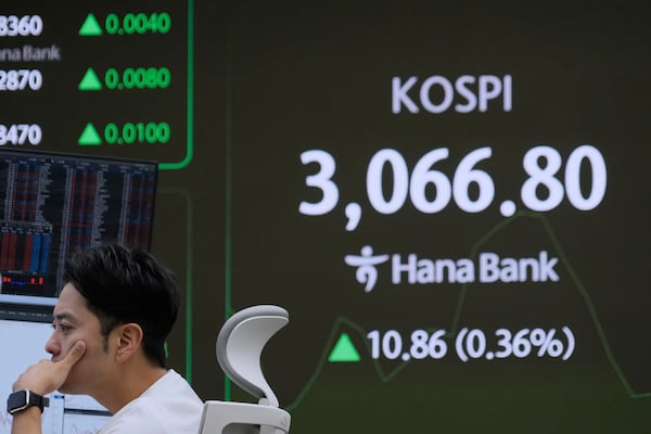 A currency trader watches monitors near a screen showing the Korea Composite Stock Price Index (KOSPI) at the foreign exchange dealing room of the KEB Hana Bank headquarters in Seoul, South Korea, Monday, June 30, 2025. (AP Photo/Ahn Young-joon)