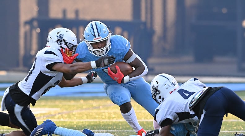 August 26 , 2022 Norcross - Meadowcreek's Jordan Louie (5) gets tackled by South Gwinnett's Daniel Hebbert (left) during the first half at Meadowcreek High School in Norcross on Friday, August 26, 2022. (Hyosub Shin / Hyosub.Shin@ajc.com)