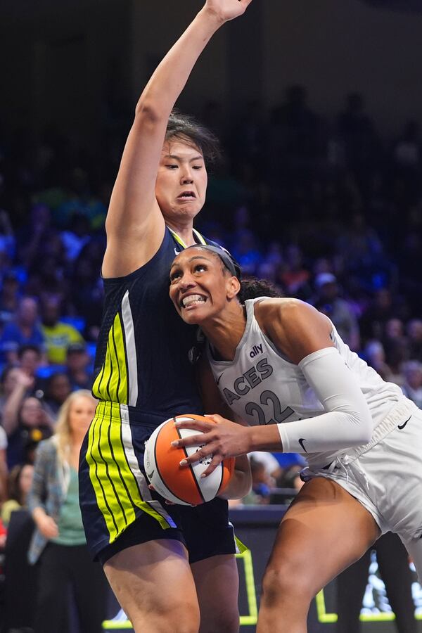 Las Vegas Aces center A'ja Wilson (22) drives against Dallas Wings center Li Yueru (28) during the second half of a WNBA basketball game in Arlington, Texas, Wednesday, July 16, 2025. (AP Photo/LM Otero)