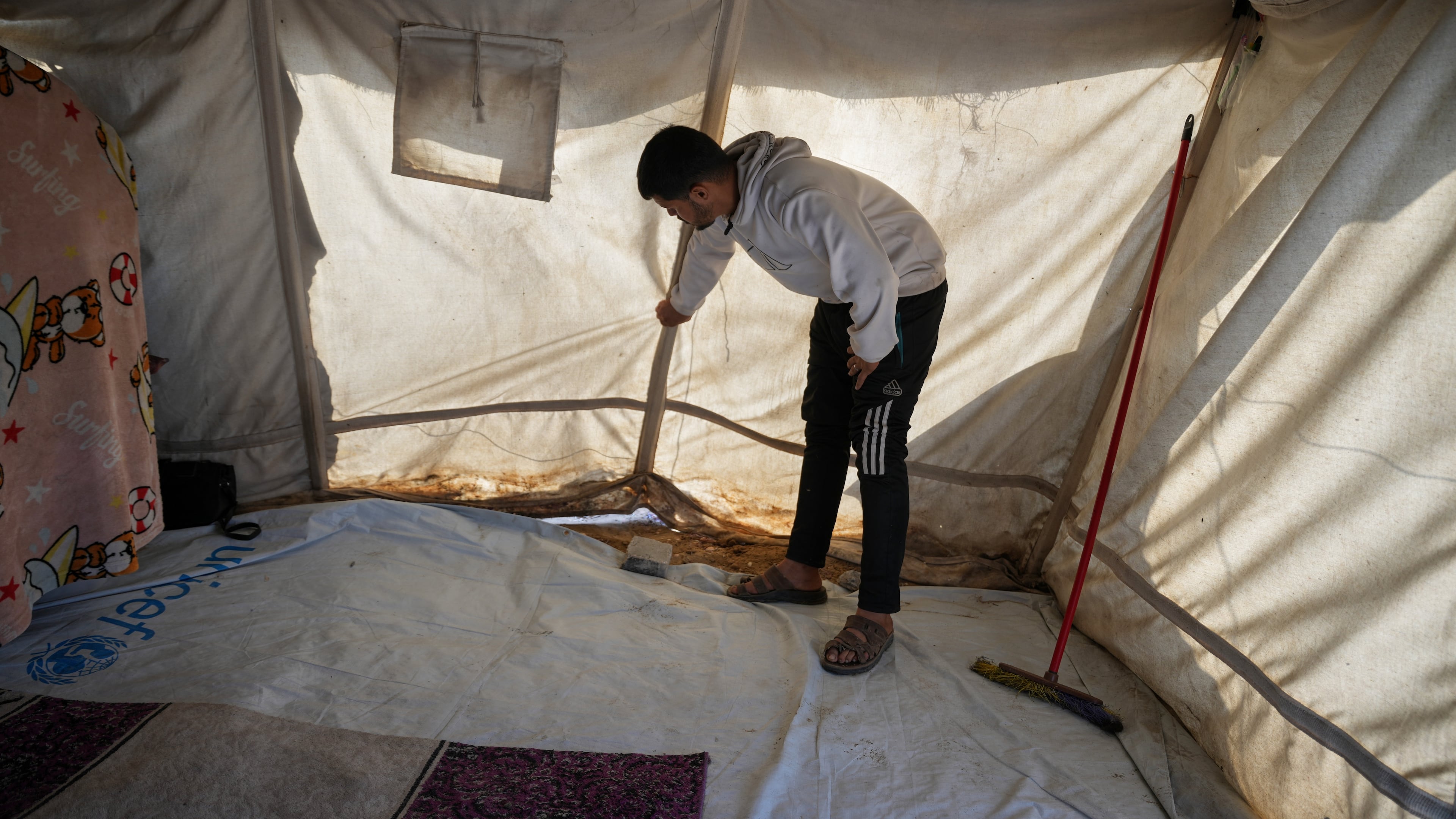 Muhannad Abu Muharib, 27, reinforces his tent after it was damaged by the storm at a temporary camp on the beach in Deir al-Balah, in the central Gaza Strip, Saturday, Nov. 15, 2025.(AP Photo/Abdel Kareem Hana)