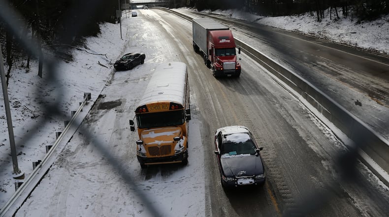 Remember this in 2014? A car police car and a tractor trailer drive past an abandon car and school buss on 166 in East Point on Wednesday afternoon January 29, 2014. BEN GRAY / BGRAY@AJC.COM