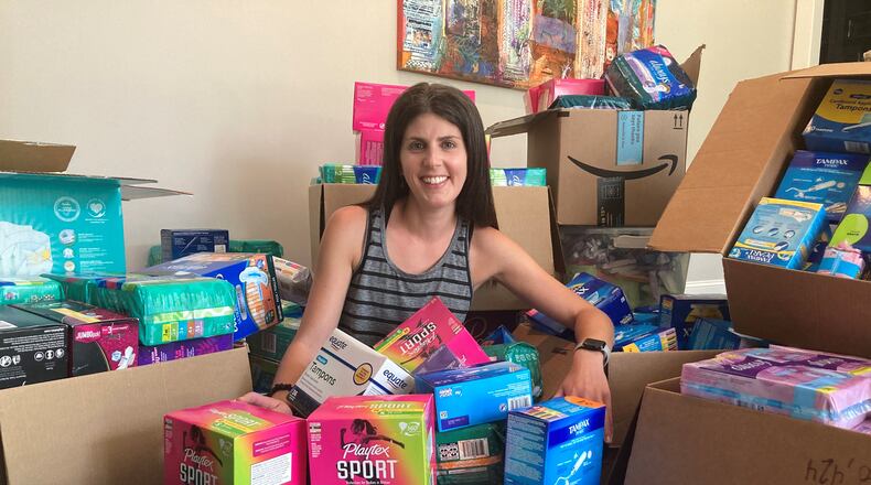 Jessica Sacks, co-chair of Project Dignity, shows off thousands of boxes of menstrual products she and volunteers collected. Courtesy of Jessica Sacks