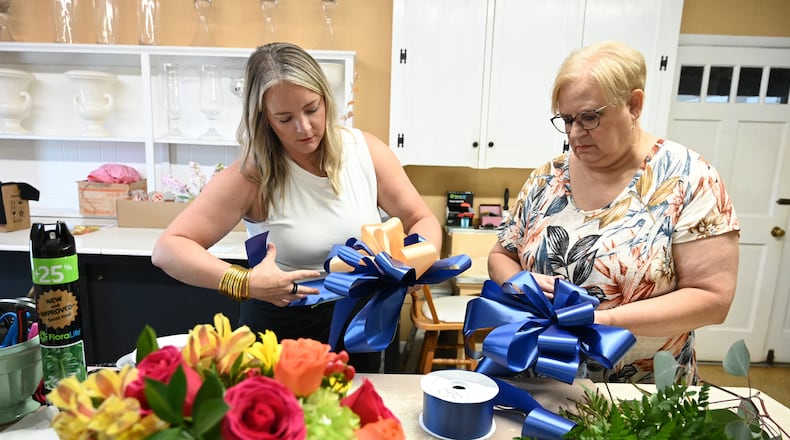 Ann's Flower and Gift Shop manager Paige Stinchcomb (left) and her mother Sherry Miller, the store's owner, make bows to support the families of victims who were killed at Apalachee High School.