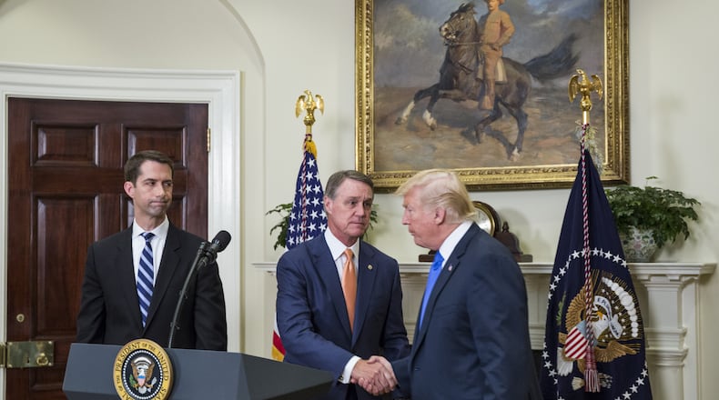President Donald Trump shakes hands with Sen. David Perdue (R-GA) during an immigration announcement at the White House in August. Zach Gibson - Pool/Getty Images