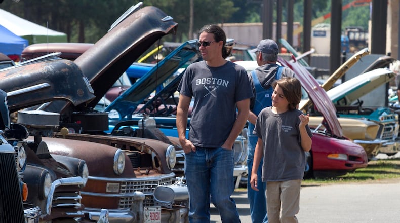 Marc Vanwinkle looks over the old restored cars with his son Rigby during last year’s Creeper’s Car Show at Jim Miller Park in Marietta. STEVE SCHAEFER / SPECIAL TO THE AJC