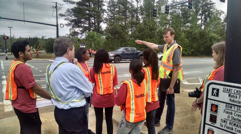 Students from Alpharetta High’s Family, Career and Community Leaders of America chapter check out the streets around the school with road and safety engineers. Contributed.