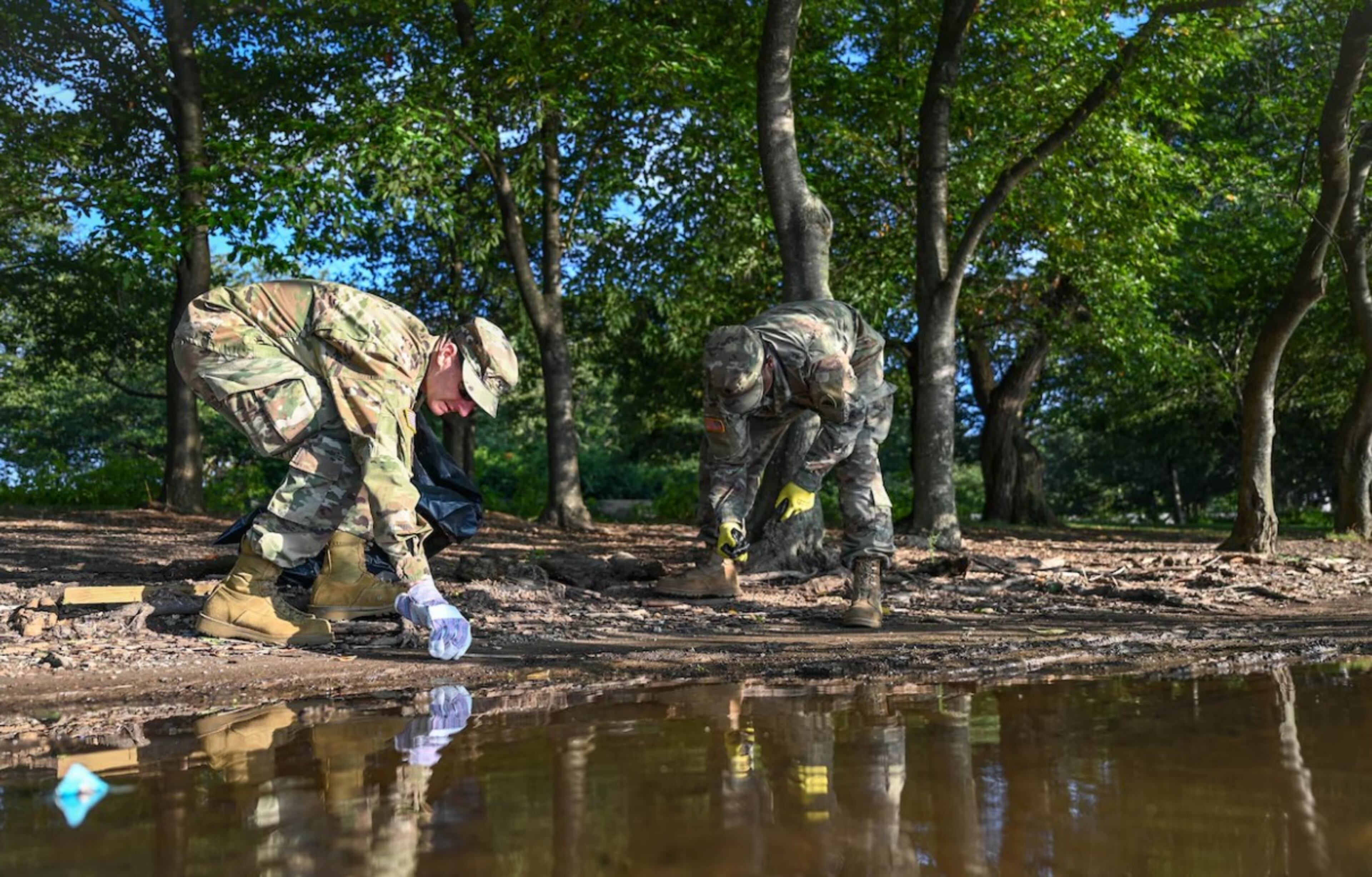 Army Col. Christopher York (left,) commander of the D.C. Safe and Beautiful Task Force, removes trash and debris along the tidal basin near the Martin Luther King Jr. Memorial in Washington on Aug. 25. (Air Force Master Sgt. Amber Monio, National Guard Bureau)