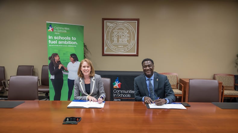 Clayton State University interim president Kerry Heyward and Communities in Schools of Atlanta CEO Frank Brown sign education partnership agreement.