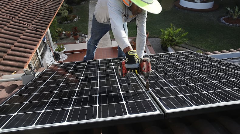 PALMETTO BAY, FL - Roger Garbey, from the Goldin Solar company, installs a solar panel system on the roof of a home a day after the Trump administration announced in January it will impose duties of as much as 30 percent on solar equipment made abroad. Daren Goldin the owner of the company said, ‘The tariffs will be disruptive to the American solar industry and the jobs they create.’ (Photo by Joe Raedle/Getty Images)