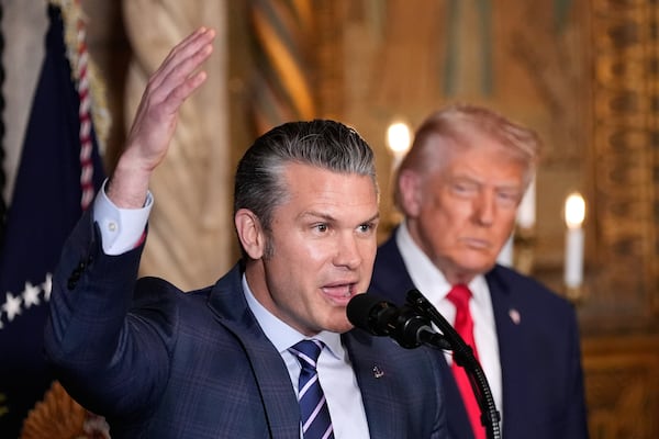 Defense Secretary Pete Hegseth speaks as President Donald Trump looks on at Trump’s Mar-a-Lago club on Monday, Dec. 22, 2025, in Palm Beach, Fla. (Alex Brandon/AP)