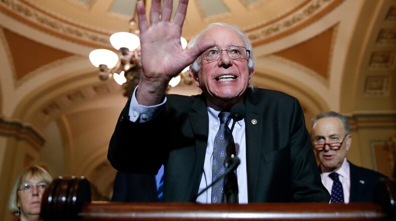 Sen. Bernie Sanders, I-Vt., center, speaks about the GOP tax bill, Tuesday. (AP Photo / Alex Brandon)